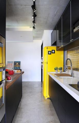Cozinha planejada em U com decoração em tons de amarelo na geladeira.