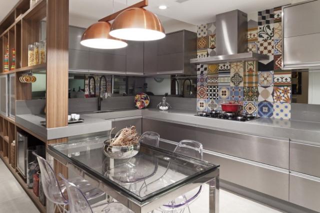 Cozinha planejada pequena planejada com detalhes em azulejos coloridos em cima do fogão.